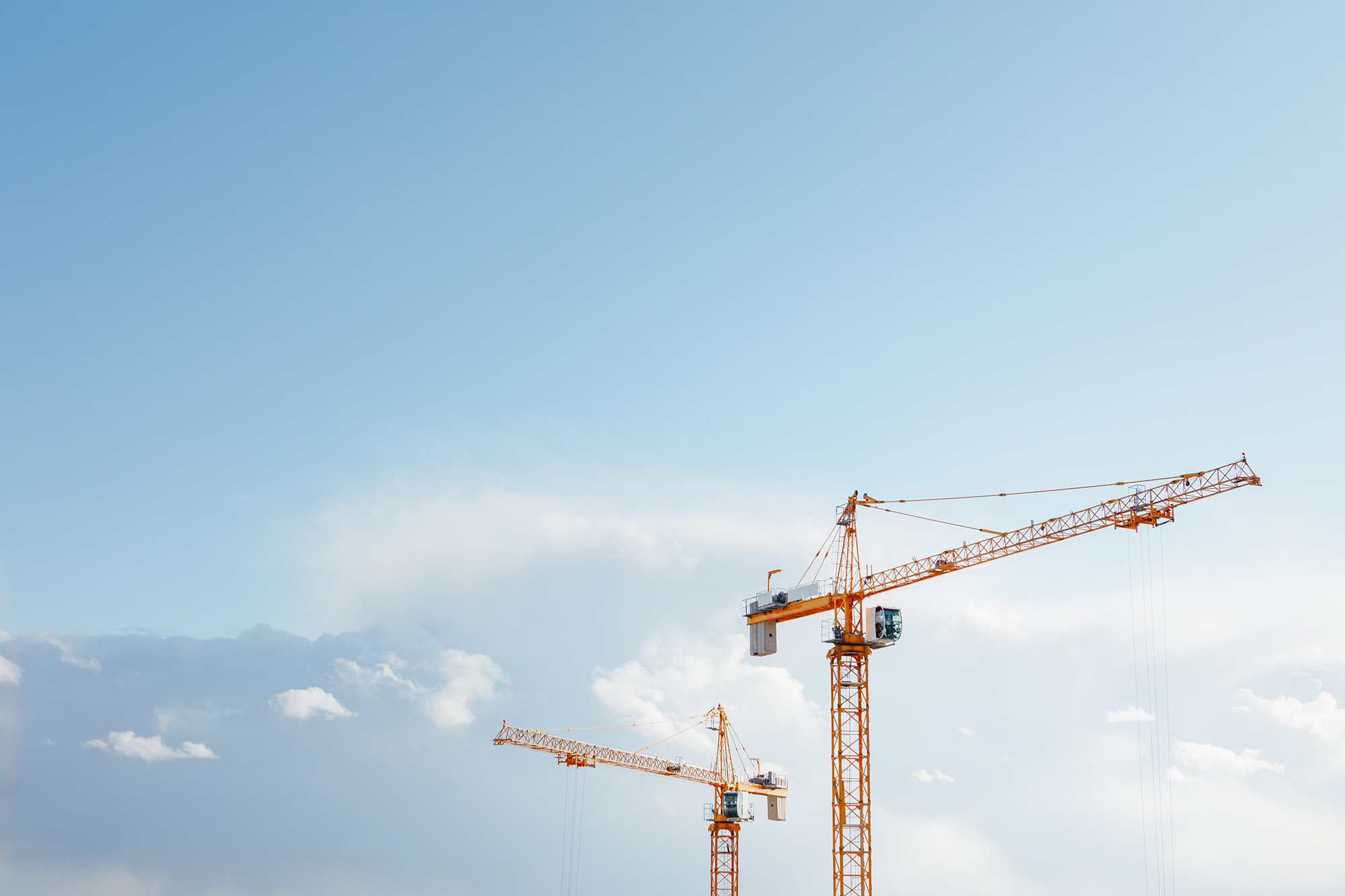 building cranes at the construction site on blue sky background